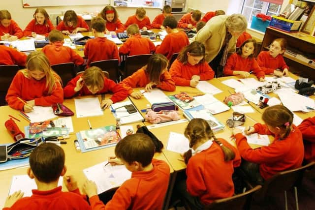 A teacher helps pupils in a lesson