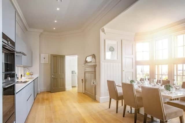 The modern kitchen features a dining area situated in a restored bay window.