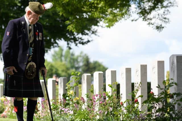 Veteran John Lamont looks at some of the gravestones ahead of the memorial service in Bayeux Cemetery on June 6.