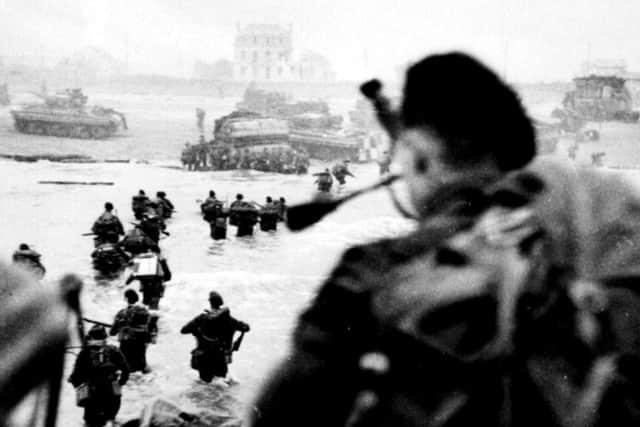 Bill Millin, the personal piper to Commander Lord Lovat, of 4 Commando, is pictured  piping his men onto Sword beach against military regulations which banned musicians from travelling to the front. PIC: PA.
