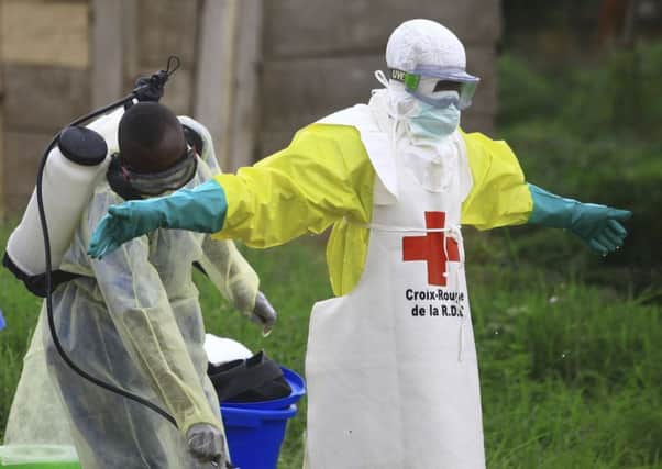 A health worker sprays disinfectant on his colleague after working at an Ebola treatment center in Beni, eastern Congo. Picture: AP Photo/Al-hadji Kudra Maliro