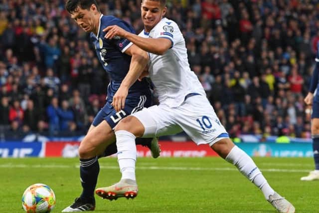 Scott McKenna vies for the ball with Cyprus forward Sotiriou Pieros