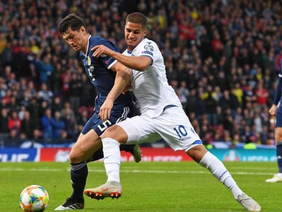 Scott McKenna vies for the ball with Cyprus forward Sotiriou Pieros