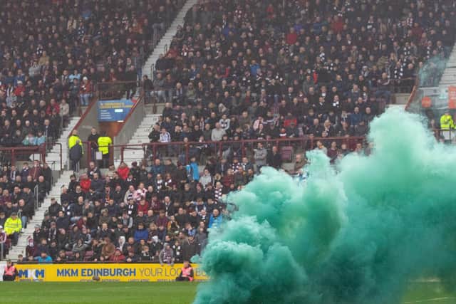 A flare is thrown onto the pitch at Tynecastle Park stadium