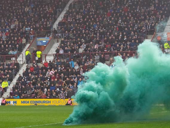 A flare is thrown onto the pitch at Tynecastle Park stadium