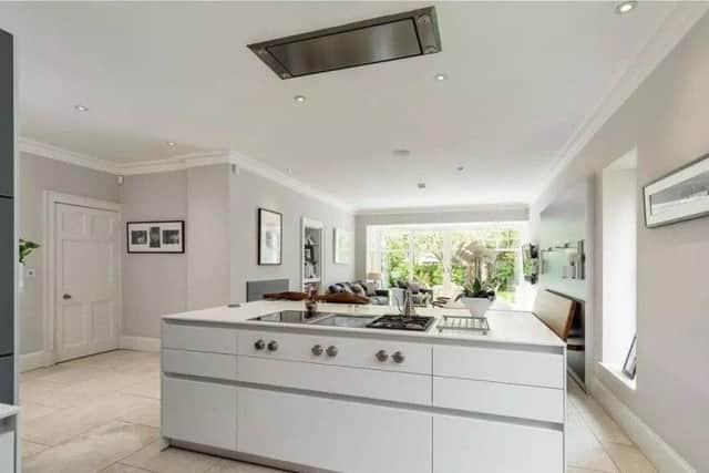 The modern kitchen has an island with hob and storage.