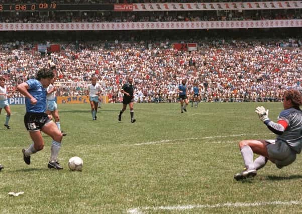 Maradona runs past English defender Terry Butcher on his way to dribbling goalkeeper Peter Shilton and scoring his second against England during the World Cup in 1986.