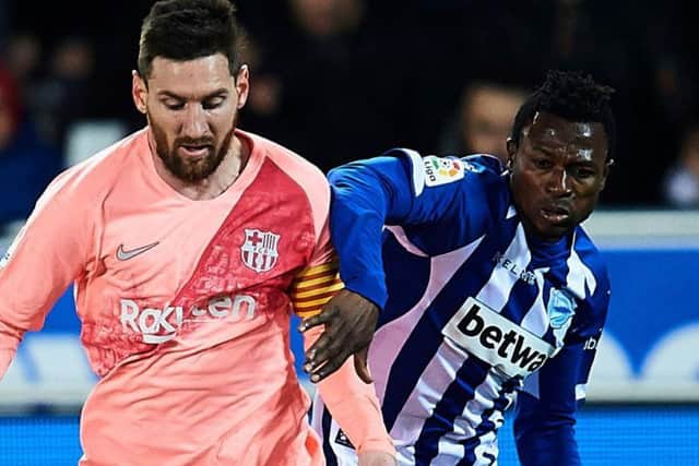 Patrick Twumasi (right) tussles with Lionel Messi