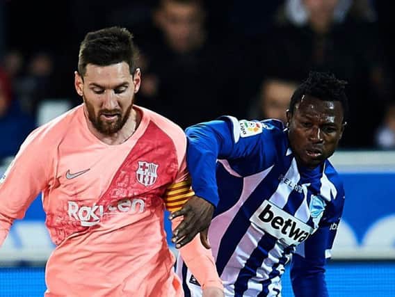 Patrick Twumasi (right) tussles with Lionel Messi