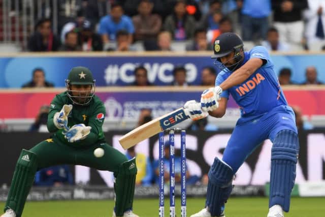 Rohit Sharma hits out during his sparkling innings of 140 at Old Trafford yesterday as Pakistans captain Sarfaraz Ahmed looks on. Picture: AFP/Getty.