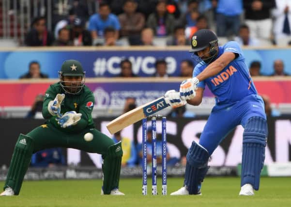 Rohit Sharma hits out during his sparkling innings of 140 at Old Trafford yesterday as Pakistans captain Sarfaraz Ahmed looks on. Picture: AFP/Getty.