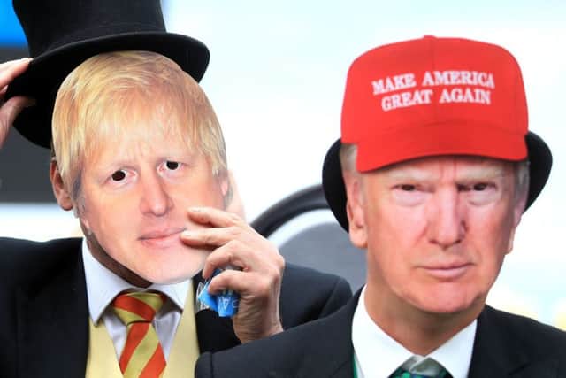 The global illiberal elite? Racegoers at Royal Ascot wear masks of Boris Johnson and Donald Trump (Picture: Adam Davy/PA)