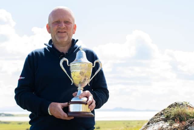 Downfield's Graham Bell gets his hands back on the Scottish Senior Men's Open trophy after his win at Luffness New. Picture: Scottish Golf