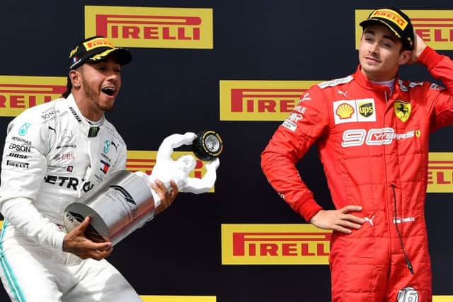 Lewis Hamilton celebrates on the podium with the French Grand Prix trophy as third-placed Charles Leclerc of Ferrari looks on. Picture: Gerard Julien/AFP