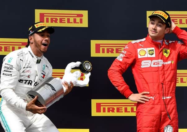 Lewis Hamilton celebrates on the podium with the French Grand Prix trophy as third-placed Charles Leclerc of Ferrari looks on. Picture: Gerard Julien/AFP