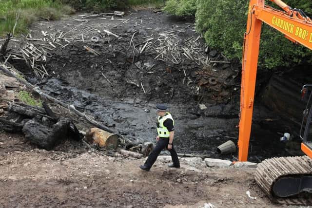 A Police officer walks past the emptied Leanach Quarry near Inverness which is being searched as part of the investigation into the disappearance of Renee and Andrew MacRae who disappeared more than 40 years ago. Picture: PA