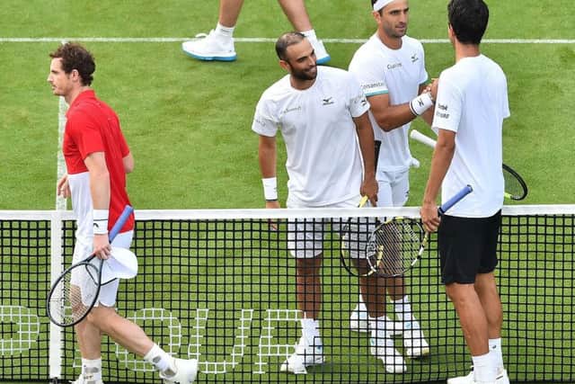 Andy Murray, left, and Marcelo Melo leave the court after losing their first-round match at Eastbourne.