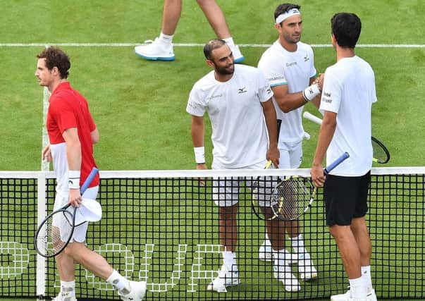 Andy Murray, left, and Marcelo Melo leave the court after losing their first-round match at Eastbourne.