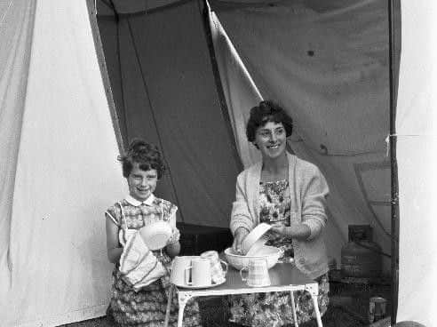 Mother and daughter wash dishes outside their tent at the Granton caravan site, on Edinburgh's Marine Drive, in July 1966. Picture: JPIMedia