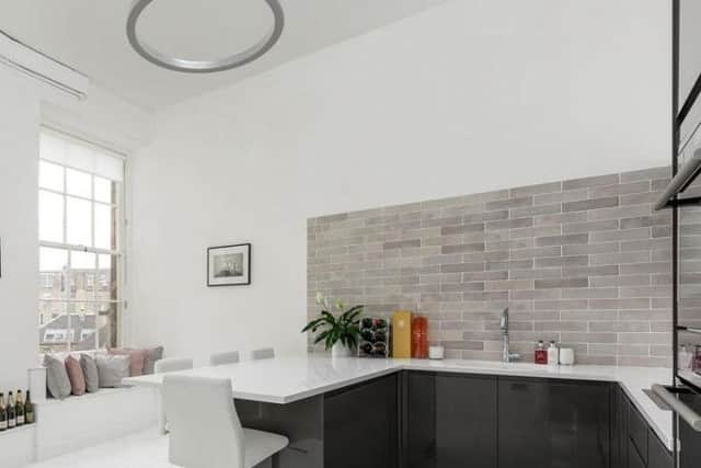 The sleek kitchen has a lovely window seat.