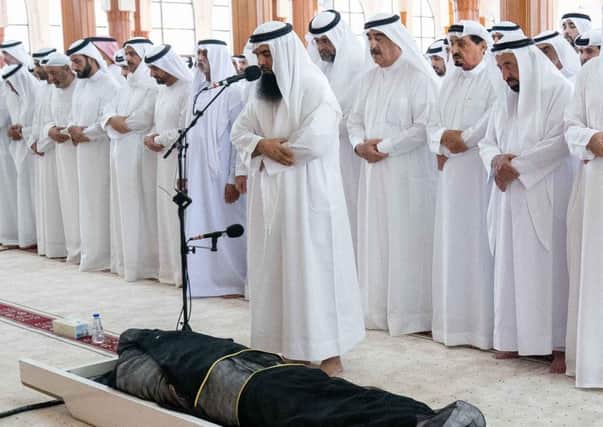 EDITORS NOTE: Graphic content / A handout image provided by United Arab Emirates News Agency (WAM) on July 3, 2019 shows Sheikh Sultan bin Muhammad al-Qasimi (6th-R), the ruler of the UAE Emirate of Sharjah, attending the funeral of his son Khalid, accompanied by the ruler of the Emirate of Ajman Sheikh Humaid bin Rashid Al Nuaimi (7th-R), the ruler of the Emirate of Ras al-Khaimah Saud bin Saqr al-Qasimi (5th-R), and the ruler of the Emirate of Umm al-Quwain Saud bin Rashid al-Mualla (8th-R). - The ruler of Sharjah's son was buried in the emirate on July 3, as a three-day mourning period began after his unexpected death in London. The government of Sharjah, one of seven emirates making up the UAE, said on July 2 that Sheikh Khalid died in London a day earlier, without elaborating further. Sheikh Khalid bin Sultan al-Qasimi was reported to be 39. London's Metropolitan Police had said the day before it was investigating an "unexplained death" in Knightsbridge but declined to reveal names. (Photo by - / WAM / A