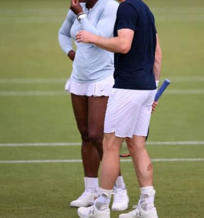 Andy Murray and mixed doubles partner Serena Williams discuss tactics during a practice session at Wimbledon yesterday. Picture: Laurence Griffiths/Getty Images