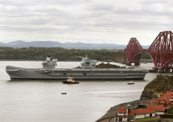 The aircraft carrier HMS Queen Elizabeth passes the Forth Bridge in 2019 following maintenance at Rosyth Dockyard. The ship was originally assembled at the Fife yard