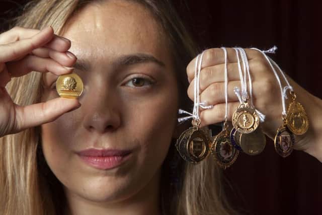 Hannah Murphy from McTear's Auctioneers with a European Cup Winner's Cup finalist medal (left) and other footballing medals, won by Rangers captain Bobby Shearer.