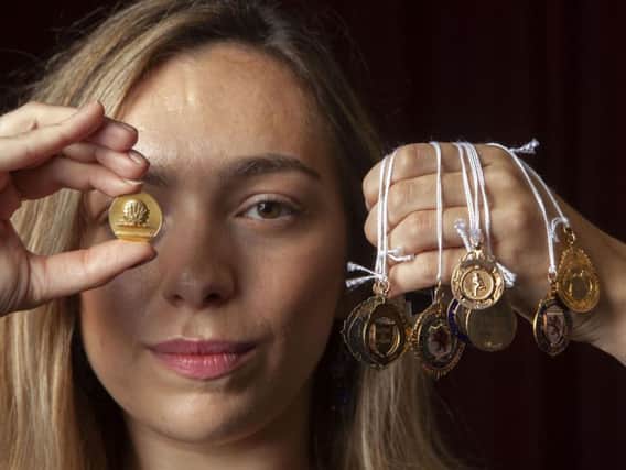 Hannah Murphy from McTear's Auctioneers with a European Cup Winner's Cup finalist medal (left) and other footballing medals, won by Rangers captain Bobby Shearer.