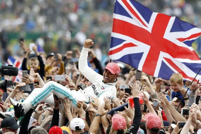 A jubilant Lewis Hamilton celebrates his victory in the British Grand Prix at Silverstone. Picture: Martin Rickett/PA Wire.