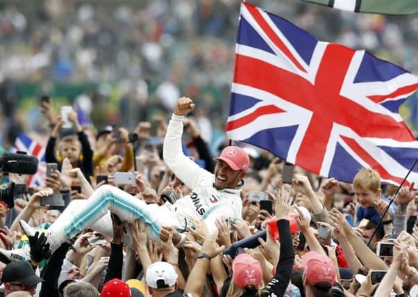 A jubilant Lewis Hamilton celebrates his victory in the British Grand Prix at Silverstone. Picture: Martin Rickett/PA Wire.