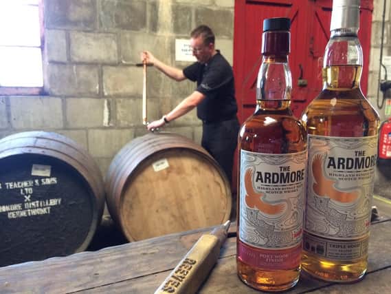 Distillery manager Alistair Longwell draws some whisky from a cask.