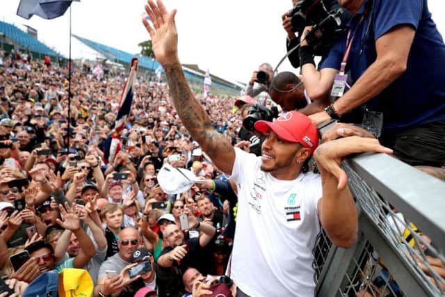 Lewis Hamilton celebrates with fans after winning the British Grand Prix at Silverstone.