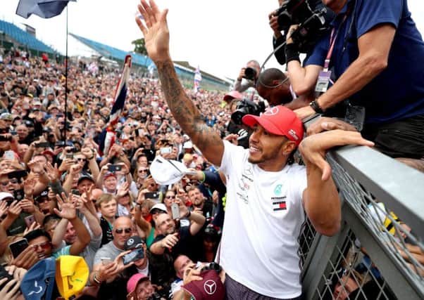 Lewis Hamilton celebrates with fans after winning the British Grand Prix at Silverstone.
