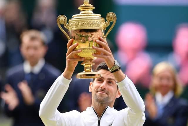 Novak Djokovic raises the Wimbledon trophy after his men's singles final victory over Roger Federer.