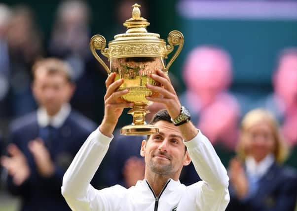 Novak Djokovic raises the Wimbledon trophy after his men's singles final victory over Roger Federer.