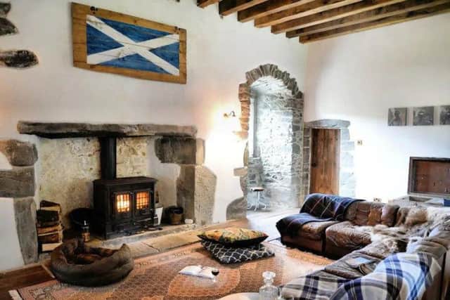 The spacious living room has original arched windows and a wood burning stove.