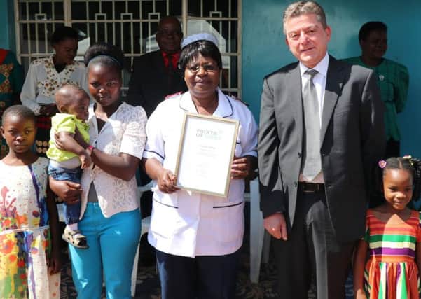 Acting High Commissioner Gary Leslie presents a Commonwealth Point of Light award to Charity Salima (Picture: British High Commmission, Malawi, @UKinMalawi)