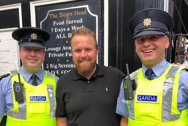 Shane Lowry is greeted by the Garda in Dublin yesterday as he Brought the Claret Jug to the Boars Head pub following his victory at Royal Portrush. Picture: PA.