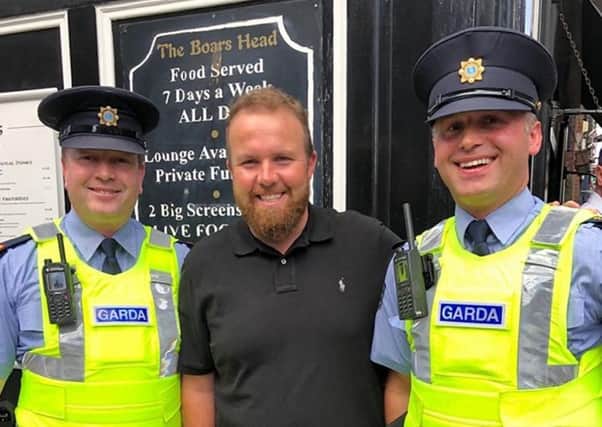 Shane Lowry is greeted by the Garda in Dublin yesterday as he Brought the Claret Jug to the Boars Head pub following his victory at Royal Portrush. Picture: PA.