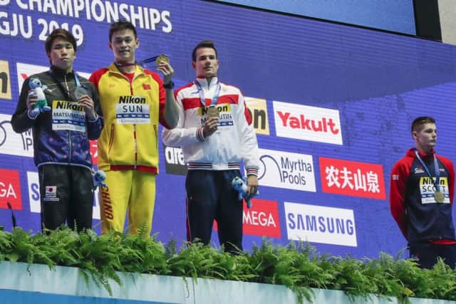 Britain's bronze medallist Duncan Scott, right, refuses to stand with gold medallist Sun Yang, second left. Picture: AP
