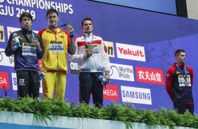 Britain's bronze medallist Duncan Scott, right, refuses to stand with gold medallist Sun Yang, second left. Picture: AP