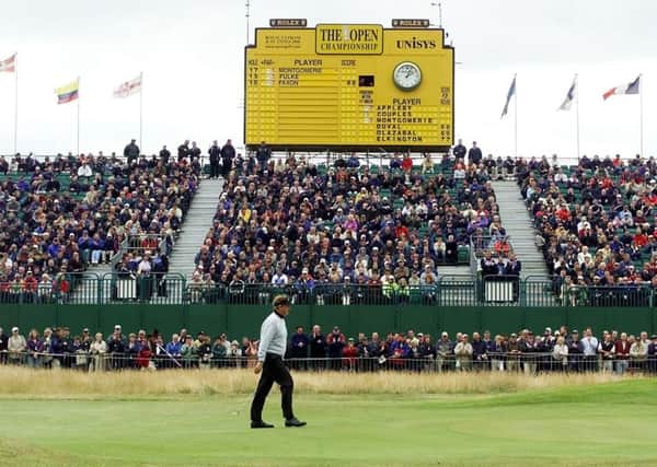 The scoreboard shows Colin Montgomerie is the early leader as the Scot is applauded by the gallery on his way to the 18th green during the first day of the Open at Royal Lytham in 2001. Picture: AFP/Getty