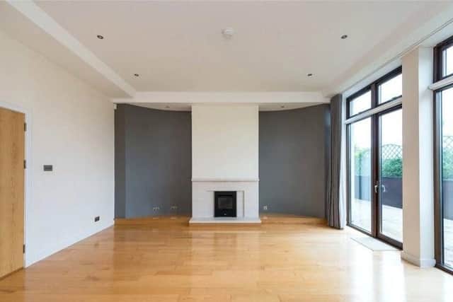 The living room has a fire place and floor to ceiling glass doors out to a terrace.