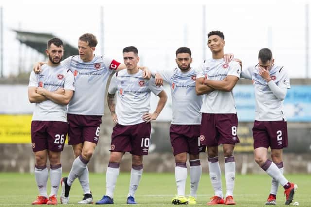 Hearts players stand dejected at the halfway line as the penalty shootout slips away from them. Picture: SNS.