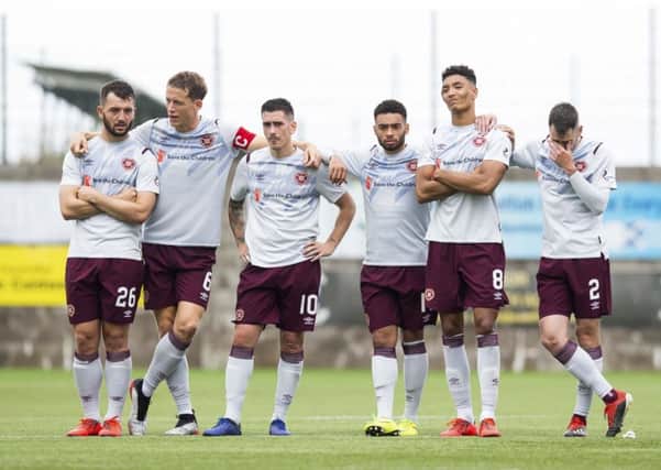 Hearts players stand dejected at the halfway line as the penalty shootout slips away from them. Picture: SNS.