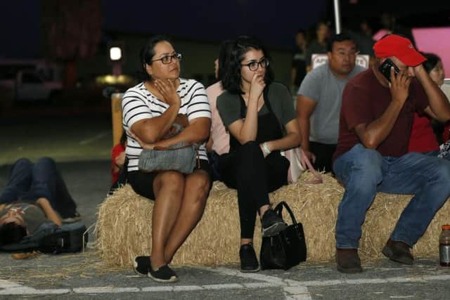 Attendees wait at a reunification centre at the festival following the shooting,