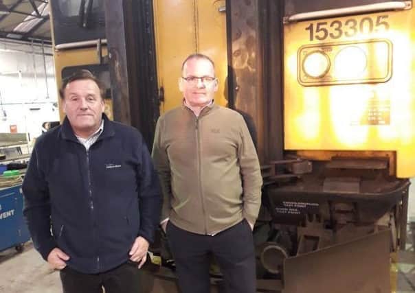 Jim Thomson and Stephen Birnie at Brodie Engineering standing in front of a Class 153 train awaiting refurbishment for ScotRail.