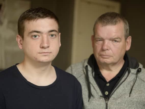 Anthony Gracey, 23, with dad Joe Gracey, 60, at home in Easthall Place, Glasgow, after police mistakenly stormed the home with a drugs warrant. Picture: SWNS