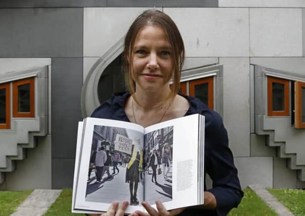 Photographer Olivia Harris pictured with her images that feature in the World Press Photo exhibition 2019, which is currently on show at the Scottish Parliament